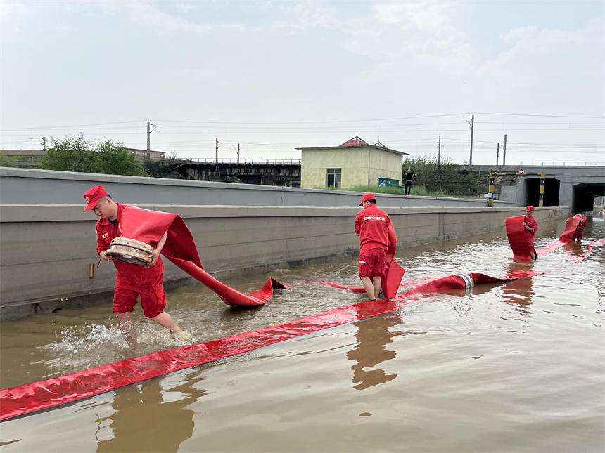 應急救援分隊隊員正使用“龍吸水”排水搶險。 徐迎華攝