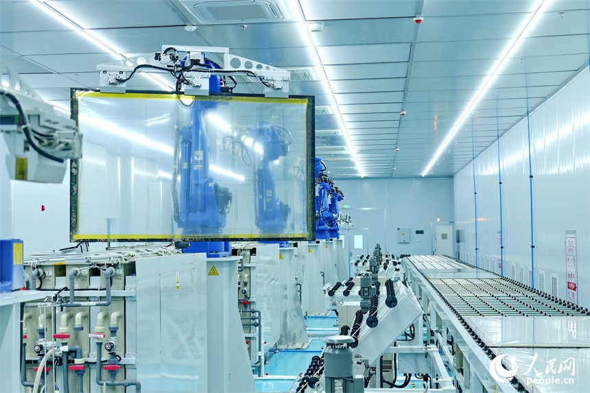一排排智能機器人正轉動機械臂加工透明導電膜。人民網 朱海鵬攝