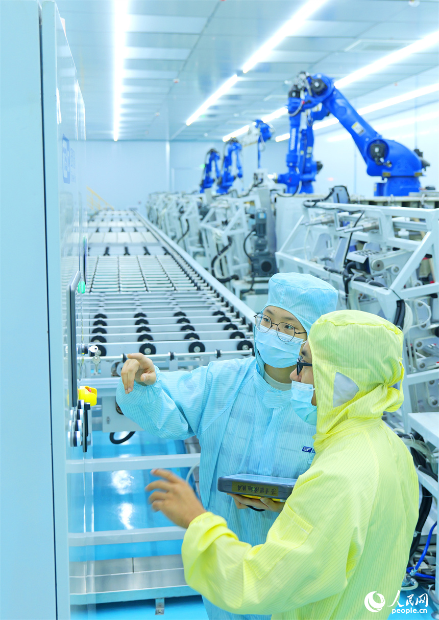 安遠縣產城新區的一家光電科技有限公司智能化生產車間內，技術工人在調試新型生產設備。人民網 朱海鵬攝