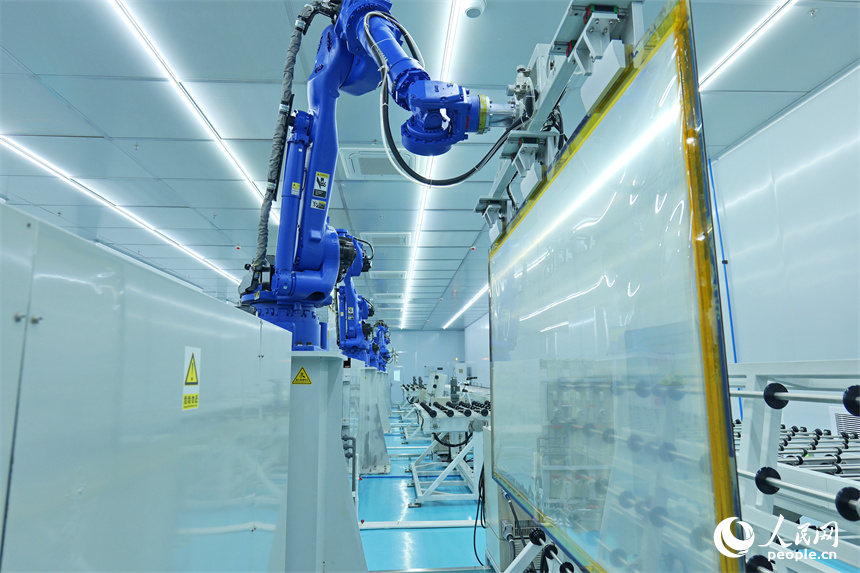 一排排智能機器人正轉動機械臂加工透明導電膜。人民網 朱海鵬攝