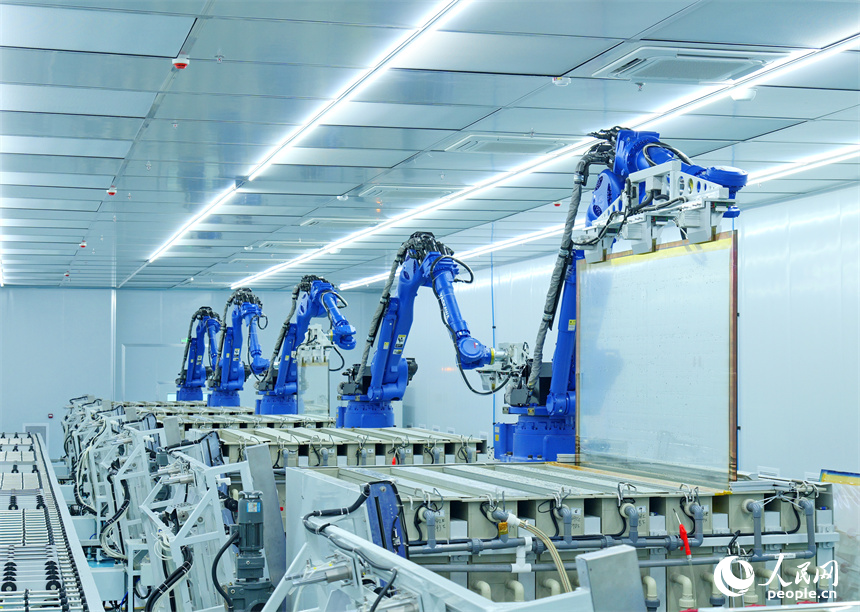 一排排智能機器人正轉動機械臂加工透明導電膜。人民網 朱海鵬攝