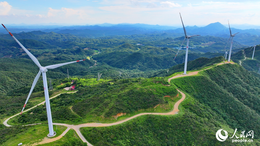 贛州市安遠縣九龍山風力發電場，隨風轉動的發電機組與藍天、白云、綠樹、青山交相輝映。人民網 朱海鵬攝