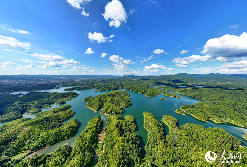 贛州市會昌縣石壁坑水庫波光粼粼，藍天白云與澄凈湖水交相輝映，構成一幅綠色生態山水畫卷。人民網 朱海鵬攝