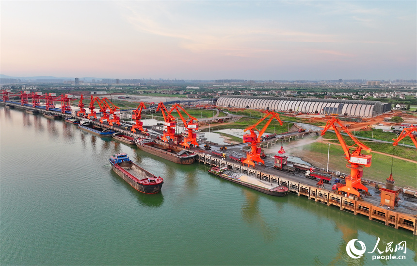 位于南昌市南昌縣的姚灣綜合碼頭，貨船、貨車來來往往，起重機裝卸作業有序進行，呈現出忙碌的景象。人民網 朱海鵬攝