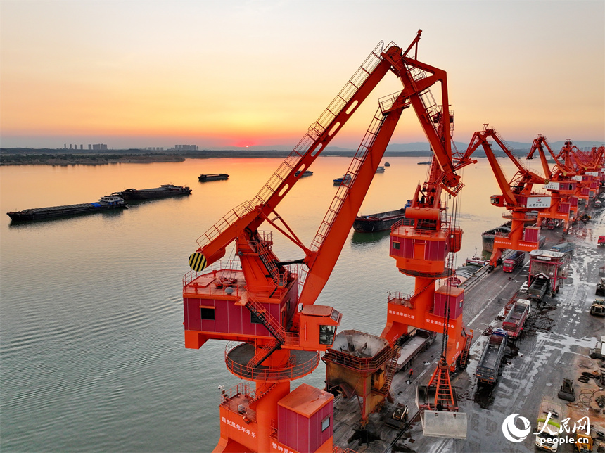 位于南昌市南昌縣的姚灣綜合碼頭，貨船、貨車來來往往，起重機裝卸作業有序進行，呈現出忙碌的景象。人民網 朱海鵬攝