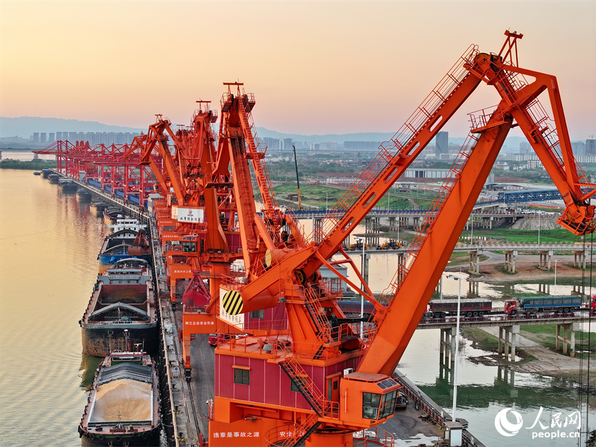 位于南昌市南昌縣的姚灣綜合碼頭，貨船、貨車來來往往，起重機裝卸作業有序進行，呈現出忙碌的景象。人民網 朱海鵬攝