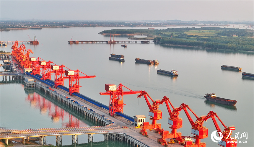 位于南昌市南昌縣的姚灣綜合碼頭，貨船、貨車來來往往，起重機裝卸作業有序進行，呈現出忙碌的景象。人民網 朱海鵬攝