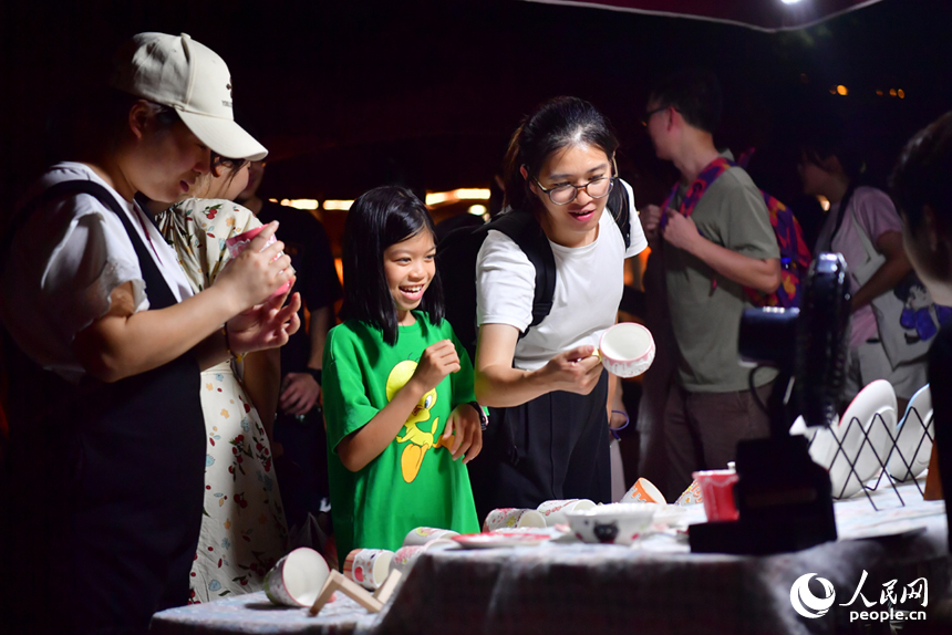 夜市上，游客們在挑選心儀的瓷器產品。人民網記者 時雨攝