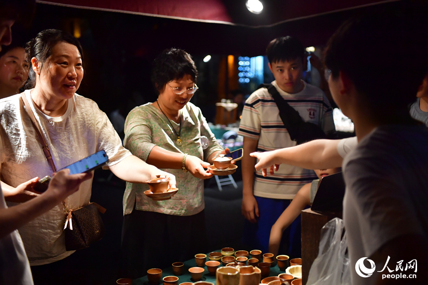 夜市上，游客們在挑選心儀的瓷器產品。人民網記者 時雨攝