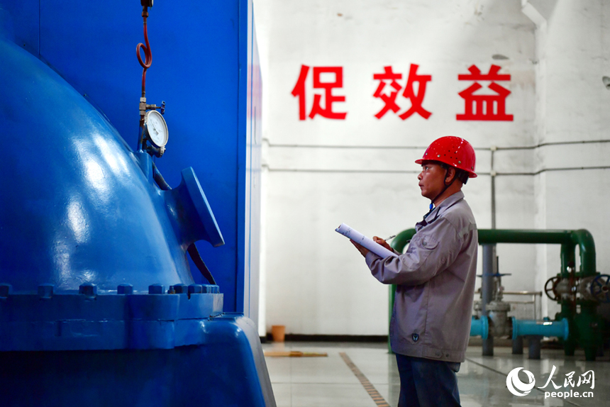 發電車間內，工人正在察看機組的運行情況。人民網記者 時雨攝