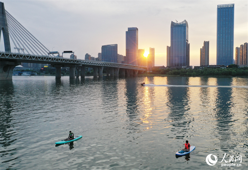 在贛江紅谷灘水域，水上運動愛好者們劃著槳板享受著水上運動帶來的樂趣。人民網記者 時雨攝