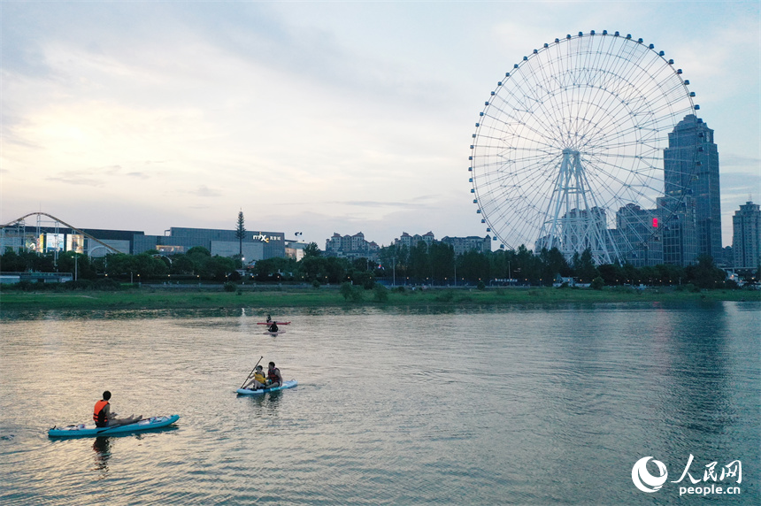 在贛江紅谷灘水域，水上運動愛好者們劃著槳板享受著水上運動帶來的樂趣。人民網記者 時雨攝