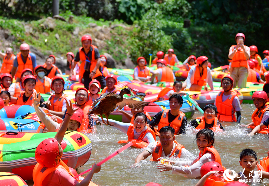 上高縣峽谷漂流水道終點，游客們正在水中參與“抓鴨子”的游戲。人民網記者 時雨攝