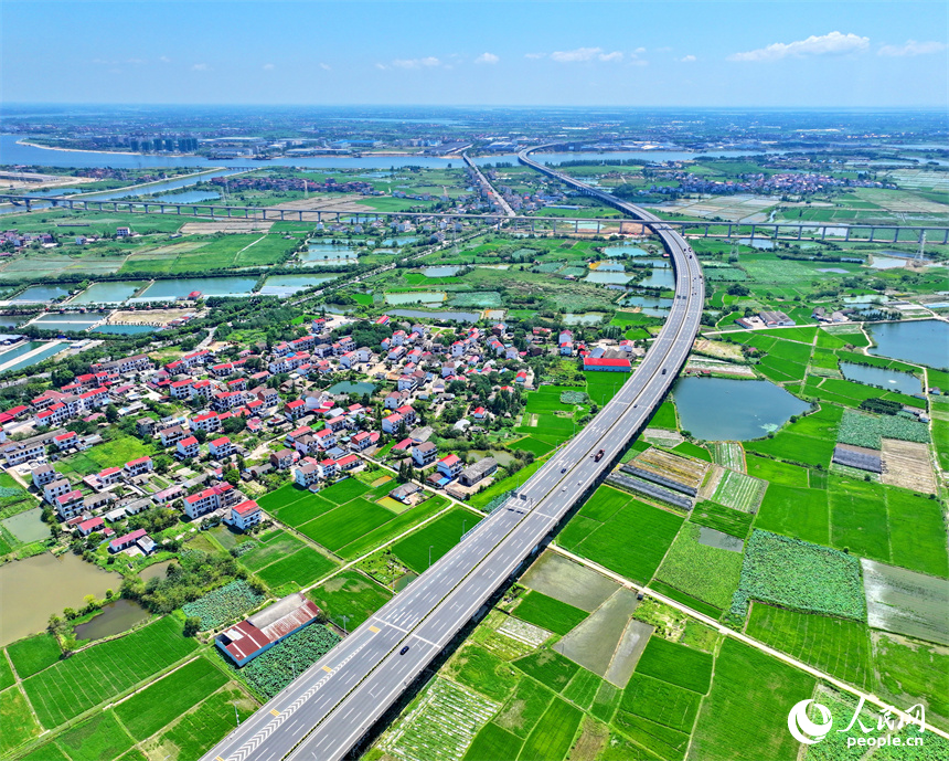 高速公路車輛往來疾馳，沿線鄉村農田密布、房舍林立，美景怡人。人民網 朱海鵬攝