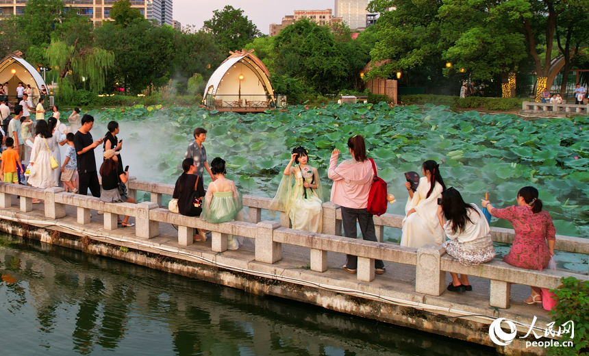 市民、游客在南昌百花洲賞荷拍照，消暑納涼。人民網記者 毛思遠攝