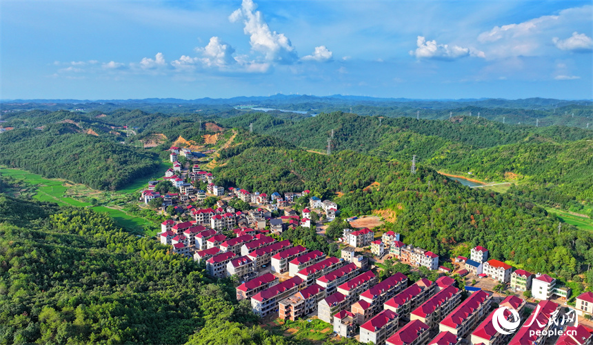 撫州市東鄉區孝崗鎮西源村的農房與通村公路、連綿青山相互映襯，美不勝收。人民網 朱海鵬攝