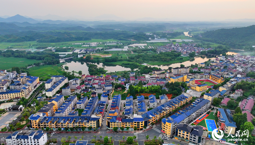 德興市張村鄉界田村，農房規劃建設有序，集鎮街道寬敞整潔，與連綿青山、蜿蜒河流、連片稻田相映成景。人民網 朱海鵬攝