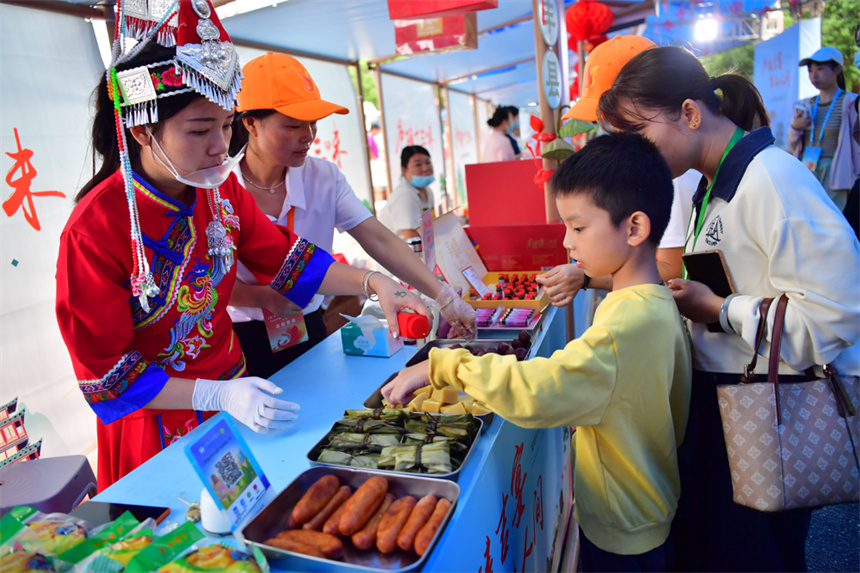 廬陵十三味美食展現場，小朋友正在品嘗畬鄉美食。人民網記者 時雨攝