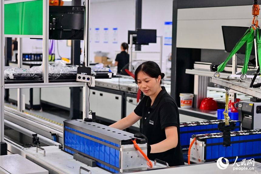 撫州市南豐縣智能制造產業園的一家儲能技術有限公司，智能機械臂來回運轉，工人在車間內忙碌。人民網 朱海鵬攝