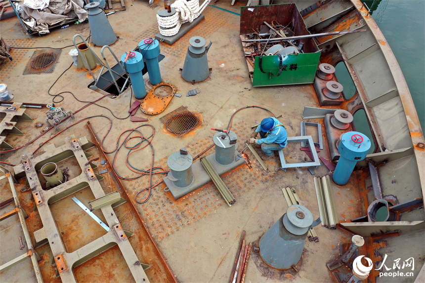 剛下水的不銹鋼化學品船停泊在湖面上，工人們正在進行船體內部的施工。人民網記者 時雨攝