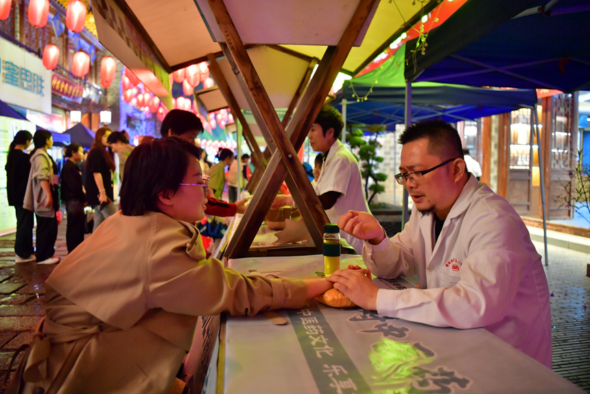 中醫在夜市上為市民把脈問診、答疑解惑。人民網記者 時雨攝
