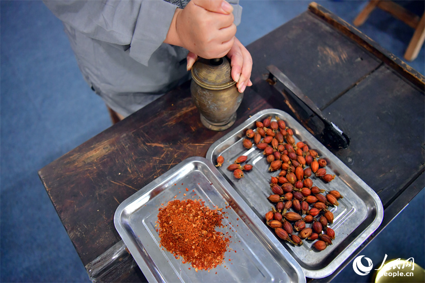 第55屆樟樹藥交會活動現場，藥工展示具有樟幫特色的炮制技藝項目。人民網記者 時雨攝