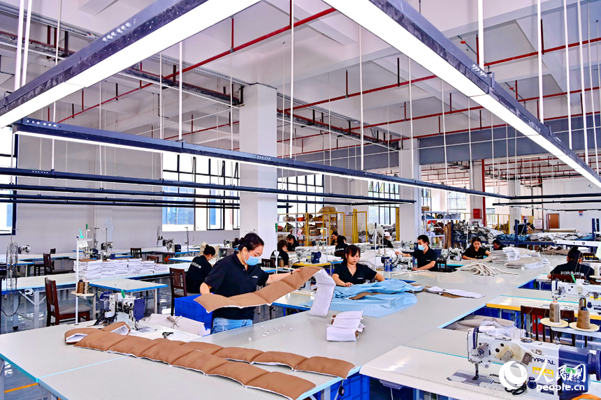 贛州市南康區經濟開發區的一家軟體家具生產企業車間內，工人在加緊制作軟包實木家具。人民網 朱海鵬攝