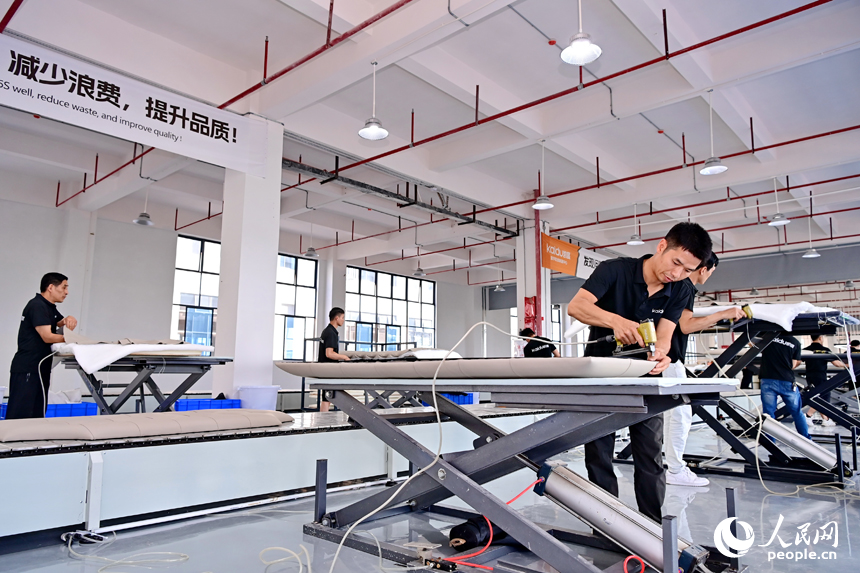 贛州市南康區經濟開發區的一家軟體家具生產企業車間內，工人在加緊制作軟包實木家具。人民網 朱海鵬攝