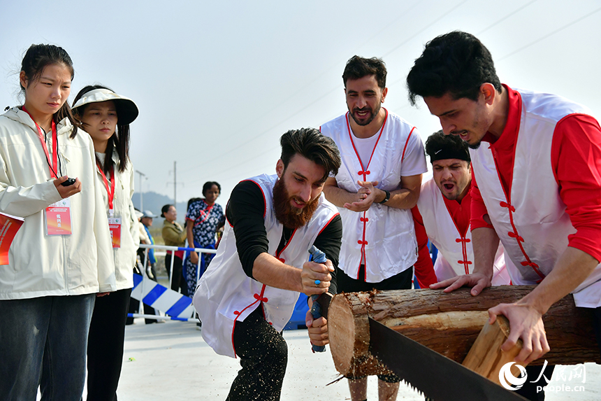留學生選手們合力完成“同心鋸木”比賽。人民網記者 時雨攝