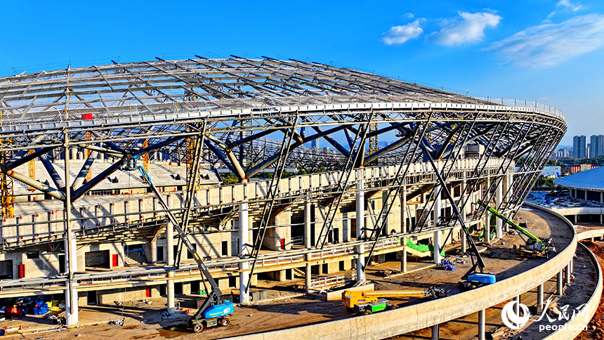 萍鄉市奧體中心項目施工現場，鋼架林立、吊裝繁忙，工人正在加緊建設各類體育場館。人民網 朱海鵬攝