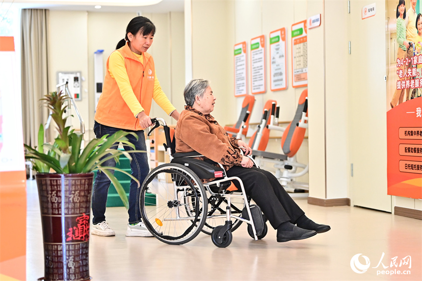 吉安市廬陵新區鳳凰社區養老中心，護工在照護行走不便的老人。人民網 朱海鵬攝
