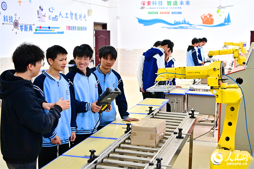 撫州市宜黃縣職業教育中心工業機器人實訓室，學生在學習工業機器人操作流程。人民網 朱海鵬攝