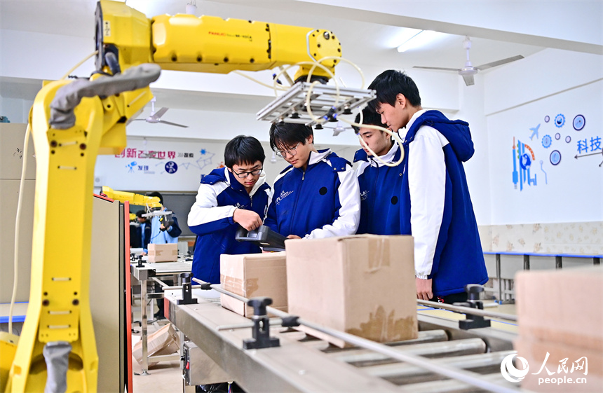 撫州市宜黃縣職業教育中心工業機器人實訓室，學生在學習工業機器人操作流程。人民網 朱海鵬攝