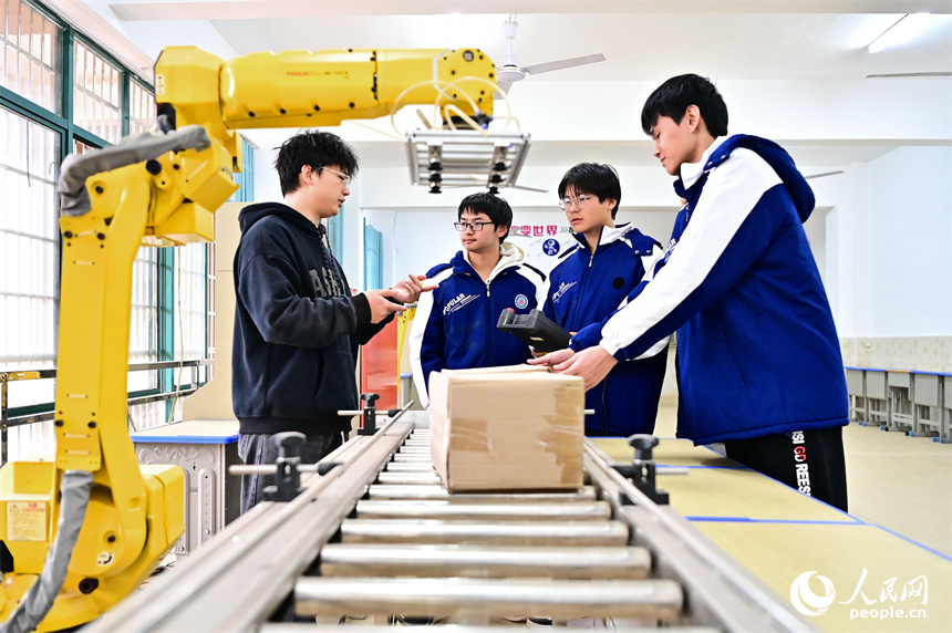 撫州市宜黃縣職業教育中心工業機器人實訓室，學生在學習工業機器人操作流程。人民網 朱海鵬攝