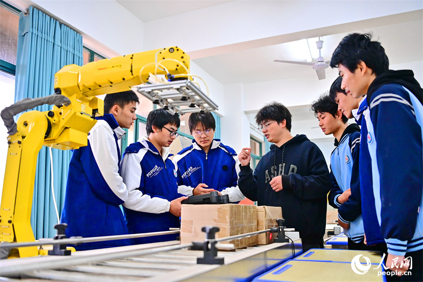撫州市宜黃縣職業教育中心工業機器人實訓室，學生在學習工業機器人操作流程。人民網 朱海鵬攝
