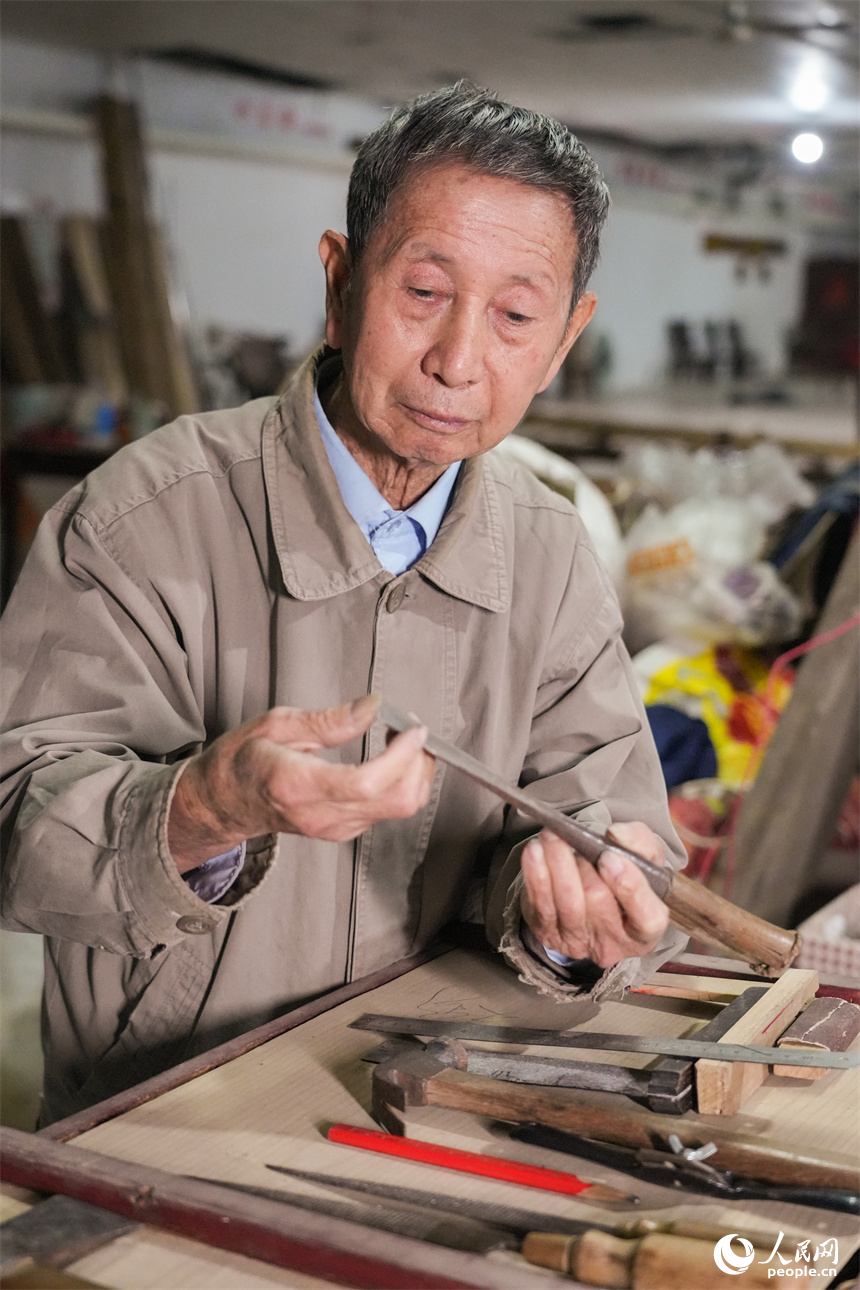 劉興林檢查造船工具。人民網 孔文進攝