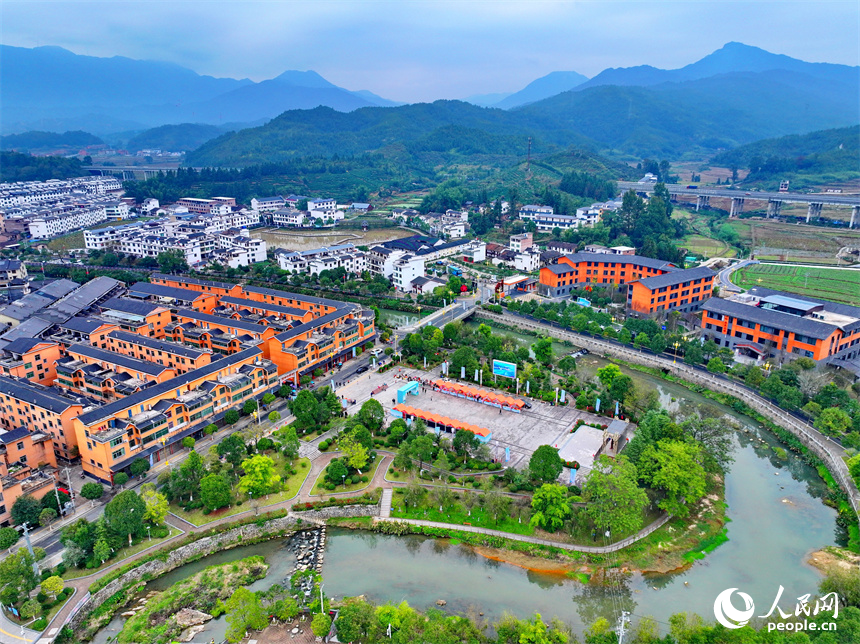 贛州市寧都縣小布鎮，鄉村公路旁的農家房屋整齊排列，與蜿蜒河流、連綿山巒相映成景。人民網 朱海鵬攝