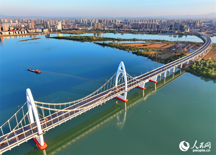 豐城市贛江水域，新建成的紫云大橋與碧水、綠樹、建筑相映成景。人民網 朱海鵬攝