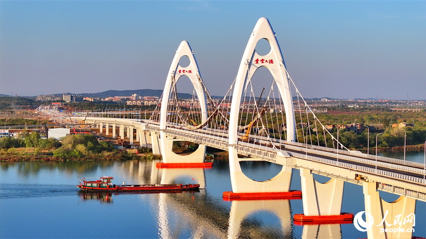 豐城市贛江水域，新建成的紫云大橋與碧水、綠樹、建筑相映成景。人民網 朱海鵬攝