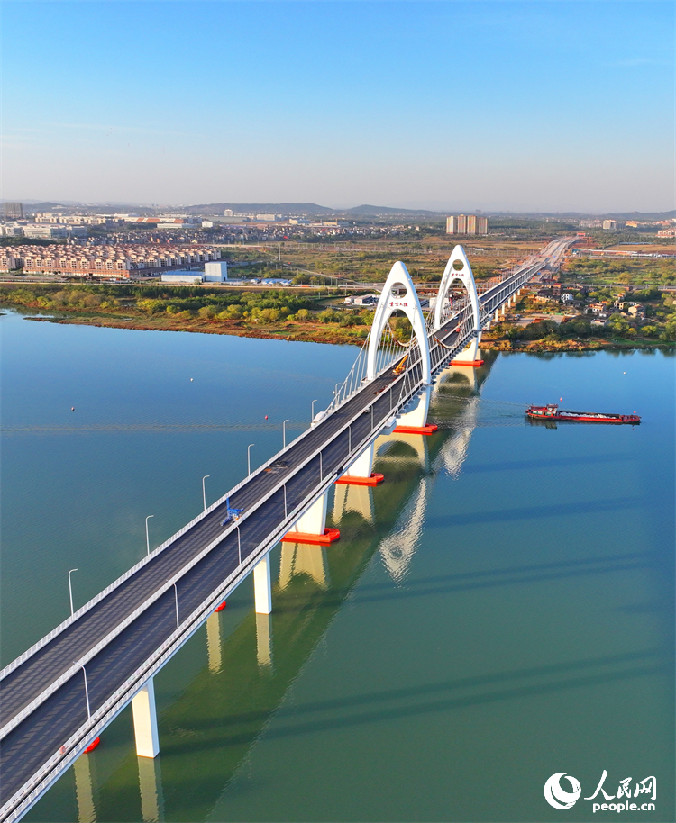 豐城市贛江水域，新建成的紫云大橋與碧水、綠樹、建筑相映成景。人民網 朱海鵬攝