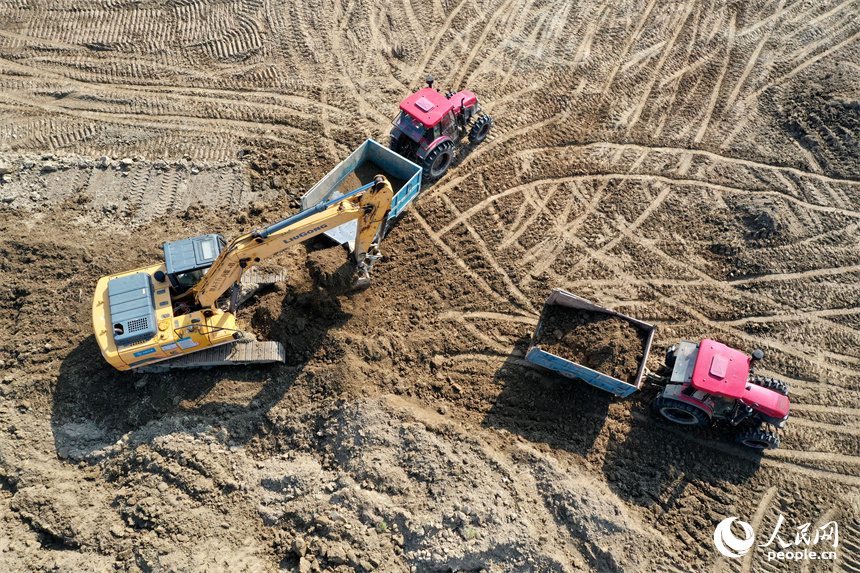 推土機、挖掘機和拖拉機搶抓冬季晴好天氣，全力推進高標準農田建設。人民網記者 時雨攝