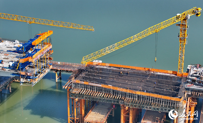 南昌隆興大橋南及連接線工程跨贛江南支引橋建設工地塔吊林立，工人在有序推進橋梁澆筑架設作業。人民網 朱海鵬攝