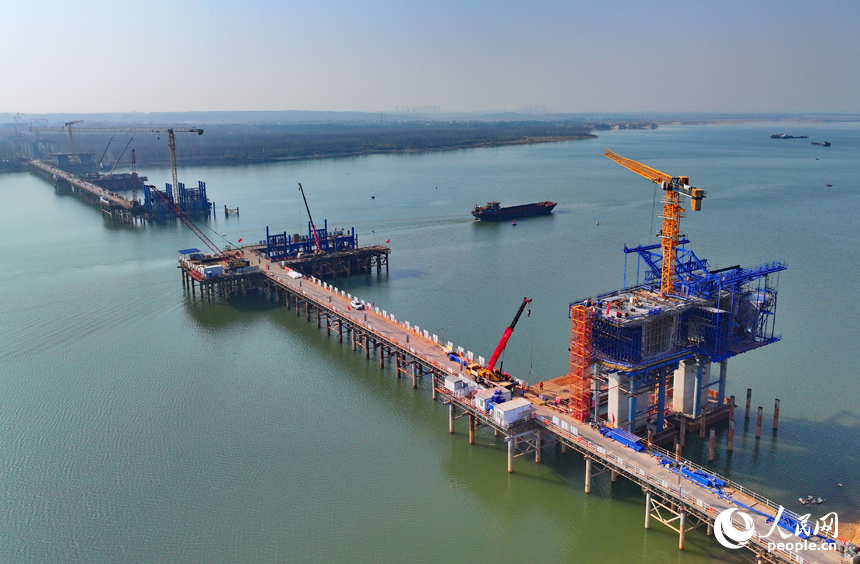 昌南大橋項目施工現場塔吊林立、機械轟鳴，工人在加緊推進橋梁承臺和引橋建設。人民網 朱海鵬攝