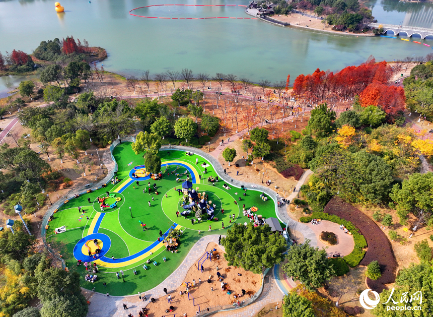 贛州市一處公園里的兒童樂園，許多家長陪伴孩子在公園里玩耍，暢享冬日暖陽，體驗新添置的玩樂設施。人民網 朱海鵬攝