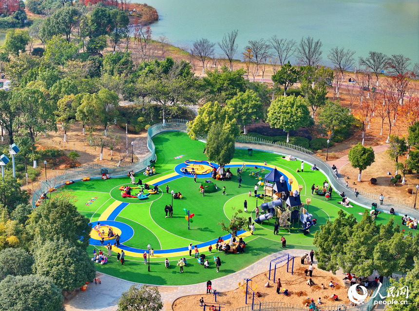 贛州市一處公園里的兒童樂園，許多家長陪伴孩子在公園里玩耍，暢享冬日暖陽，體驗新添置的玩樂設施。人民網 朱海鵬攝
