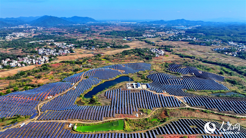 贛州市信豐縣正平鎮的一處農光互補光伏發電基地，太陽能光伏板與青山綠樹、村莊田園相映襯。人民網 朱海鵬攝