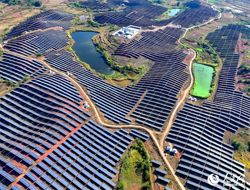 贛州市信豐縣正平鎮的一處農光互補光伏發電基地，太陽能光伏板與青山綠樹、村莊田園相映襯。人民網 朱海鵬攝