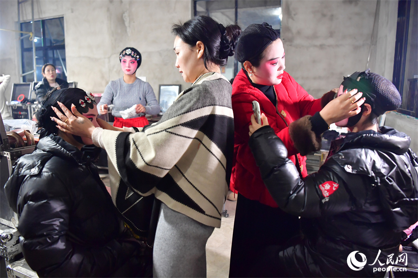 臨時搭建的劇團后臺里，劇團演員正在為年輕一代的演員化妝。人民網記者 時雨攝