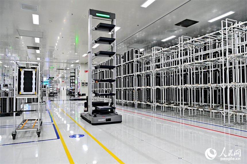 豐城市高新技術產業園區的一家汽車電子企業內，AGV運輸車來回運轉有序作業，工人在加工車載電子產品。人民網 朱海鵬攝