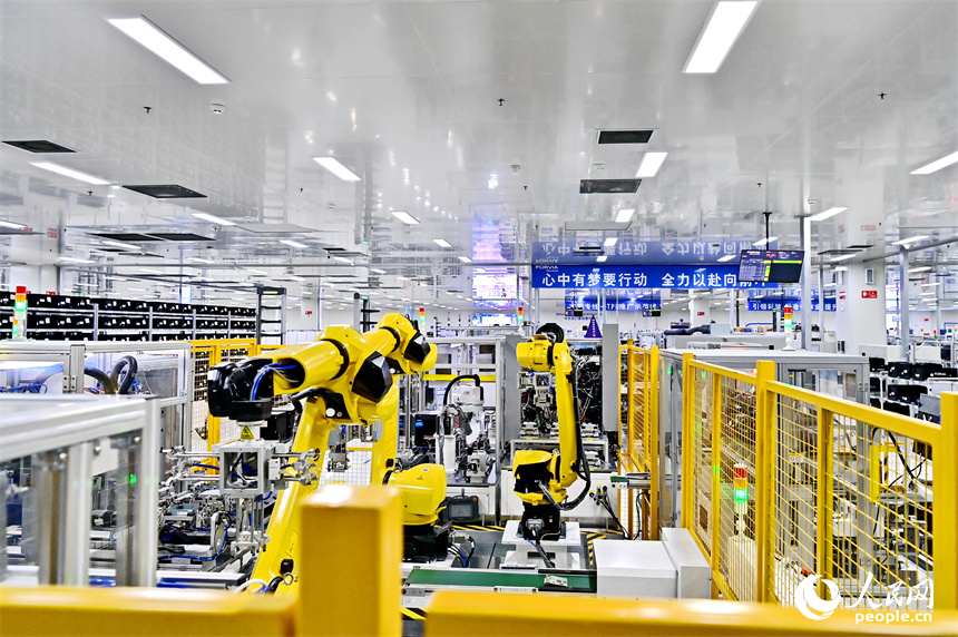 豐城市高新技術產業園區的一家汽車電子企業內，AGV運輸車來回運轉有序作業，工人在加工車載電子產品。人民網 朱海鵬攝